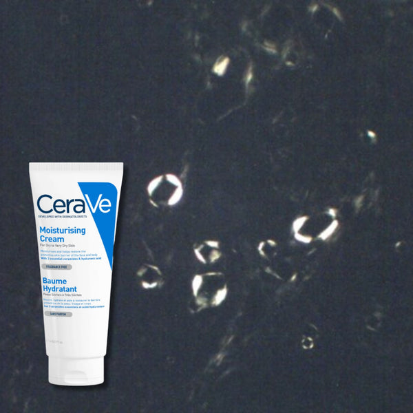 Cross-polarized microscopy of CeraVe Moisturizing Cream showing a small central cluster of Maltese cross structures with the surrounding field largely dark.