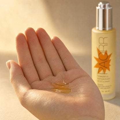 Golden Paorr organic Moroccan argan oil by Zerafite pooled in an open palm, the bottle behind.
