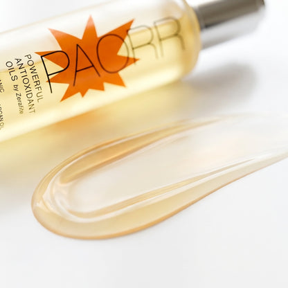 A swatch of clear golden Paorr organic Moroccan argan oil by Zerafite pooled beside the bottle.