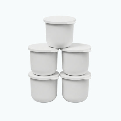 Five white Zerafite Skin Brightening Barrier Cream refill pods stacked in a pyramid.