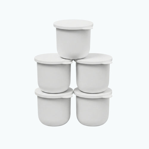 Five white Zerafite Skin Brightening Barrier Cream refill pods stacked in a pyramid.