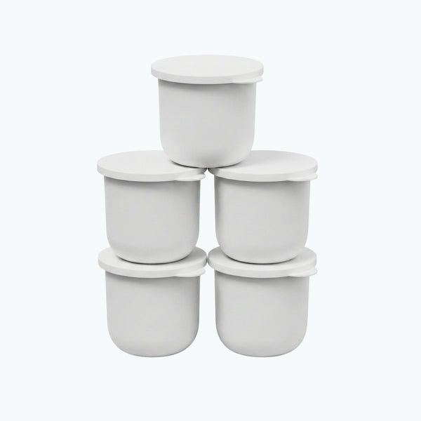 Five white Zerafite Skin Brightening Barrier Cream refill pods stacked in a pyramid.